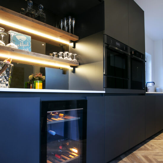 Black Kitchen with wine fridge and bar area. Tall Feature Image. Designed by John Willox Kitchen Design