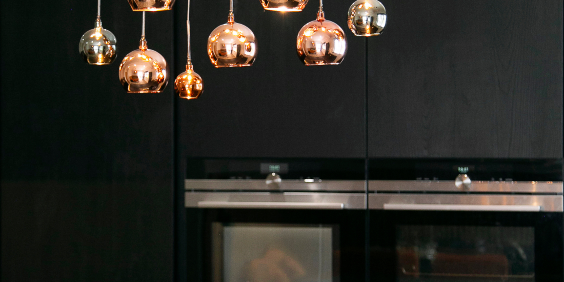 Dark Wood Handless Kitchen with Brass lighting. Designed by John Willox Kitchen Design