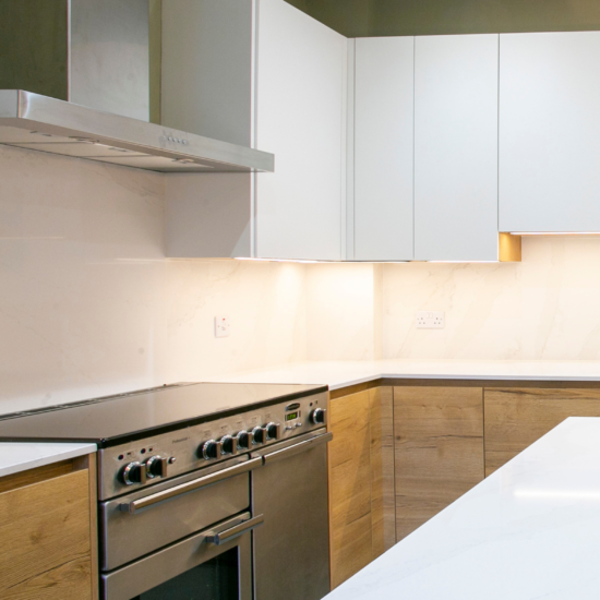 Wooden effect and white handless kitchen with range cooker by John Willox Kitchen Design