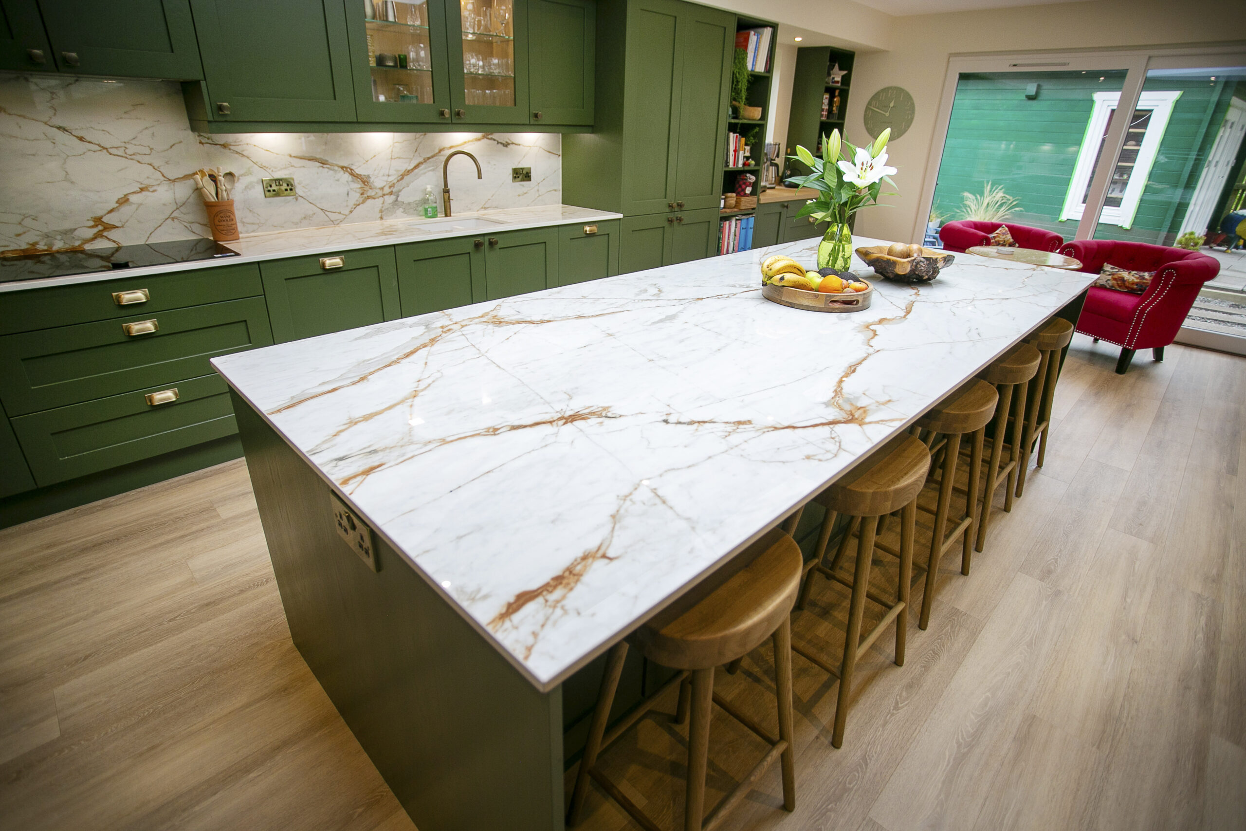 Bespoke Green Shaker Kitchen Design with Dekton Awake worktops and splashbacks. Bronze Accents. John Willox Kitchen Design Aberdeen. Ellon. Green Kitchen. Kitchen Island. Large L-Shaped Kitchen.