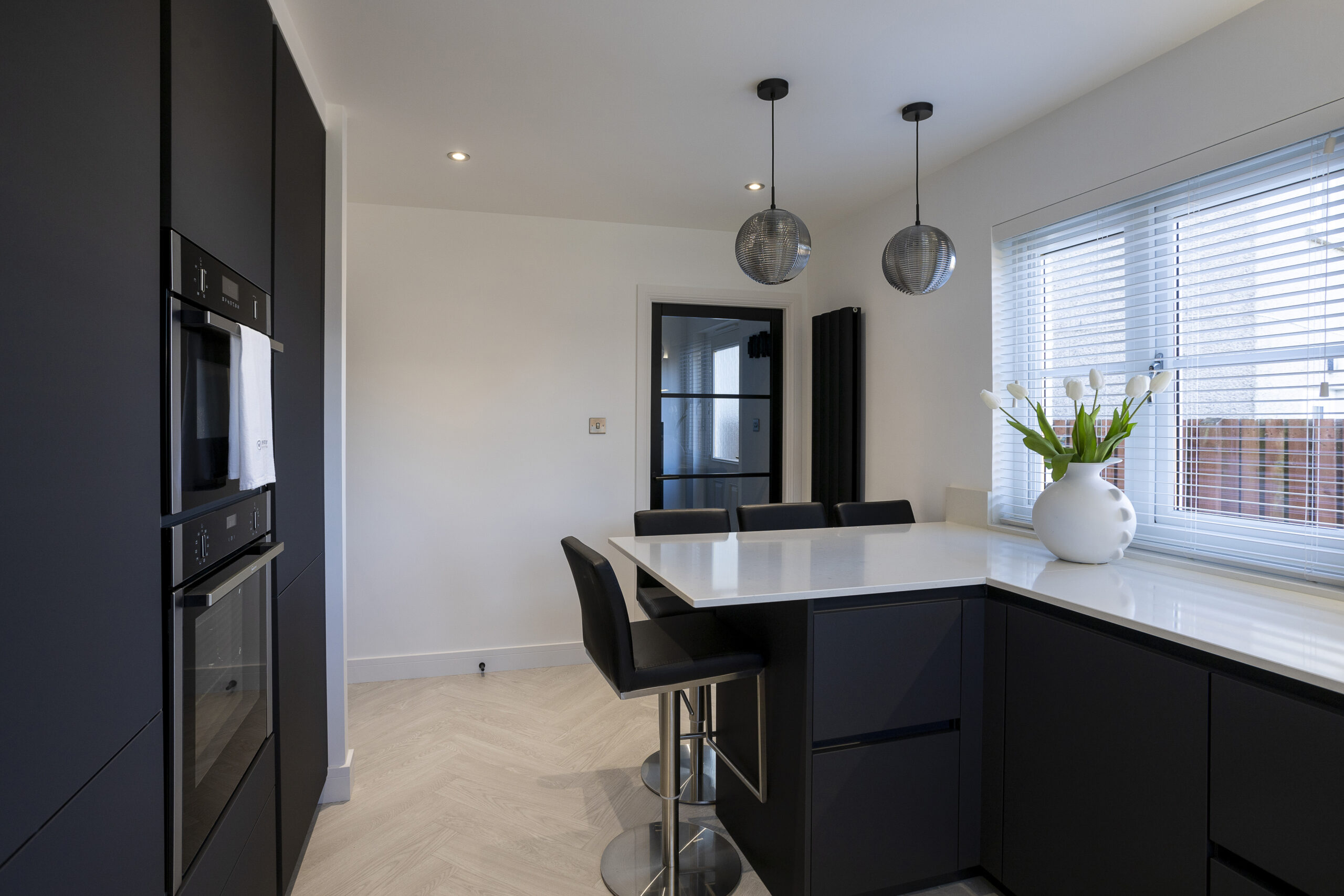 Black vs White Kitchen with tall built in cabinets and breakfast bar by John Willox Kitchen Design, Ellon.