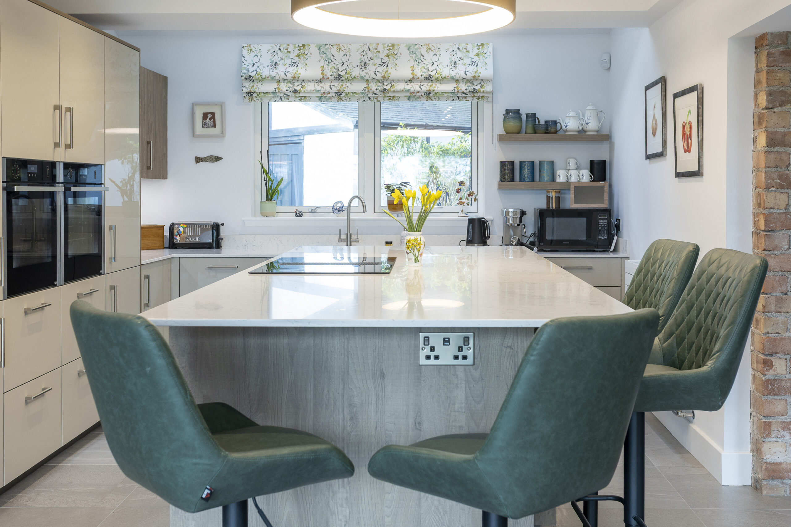 Island or peninsula? John Willox Project Story open plan cream kitchen with soft wood tones. Centered around an island.