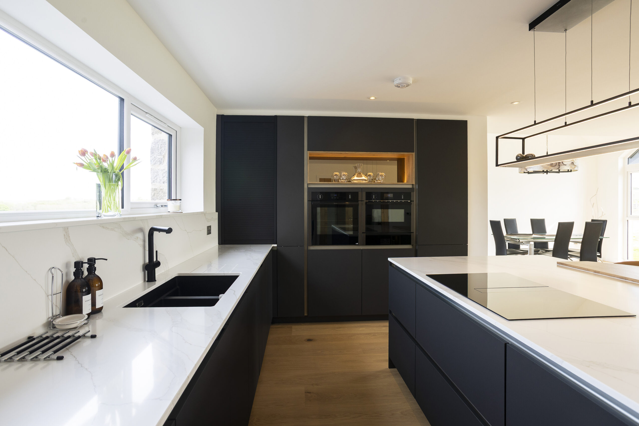 Carbon Black Kitchen. U Shape with Island. Silk Stone Bardalino white stone worktops laced with gold veiningJohn Willox Kitchen Design, Ellon, Aberdeen.
