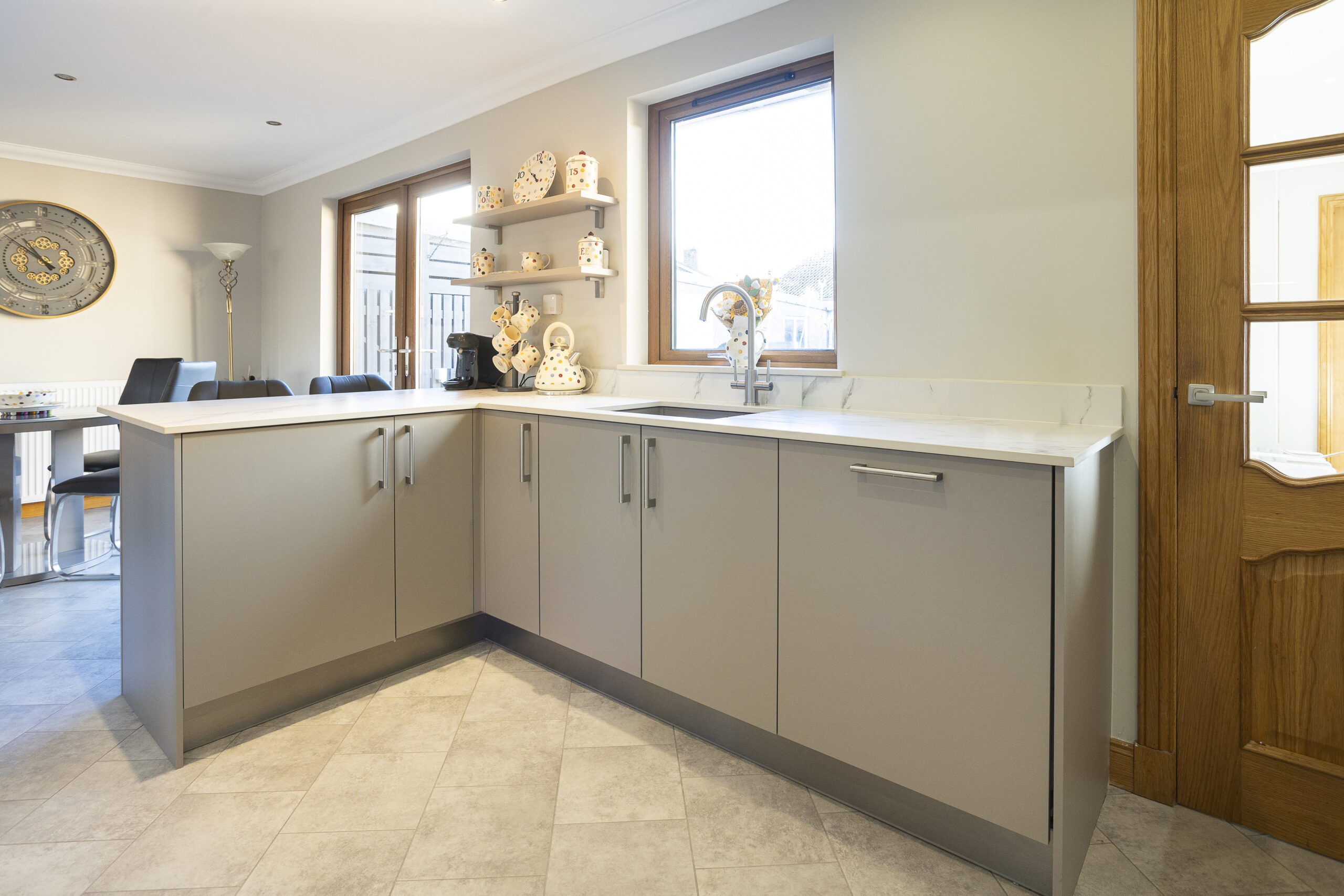Quiet Elegance. John Willox Kitchen Design L-Shaped Peninsula. Beige Toned Kitchen with Stainless Steel Sink.